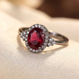 Zilveren ring met robijn en stralenkrans