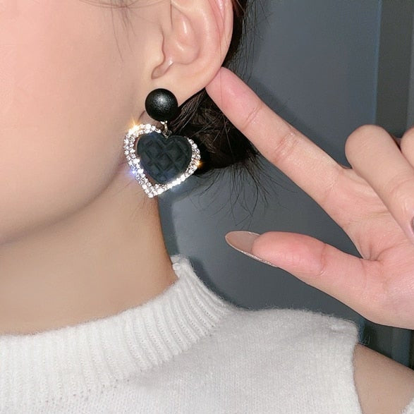 Schwarze goldene herzförmige Ohrringe
