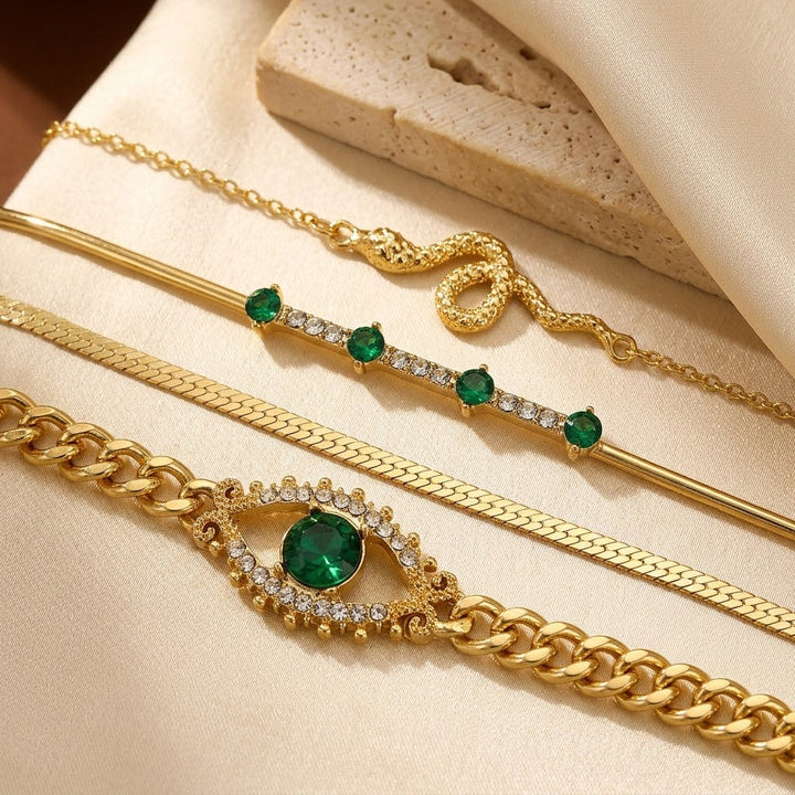 Gouden set armbanden met bedels en smaragd